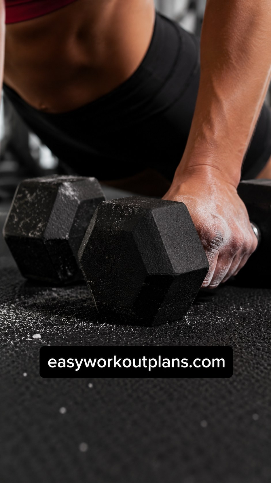 Close-up of hands gripping hex dumbbells, the hand position used in dumbbell floor core work